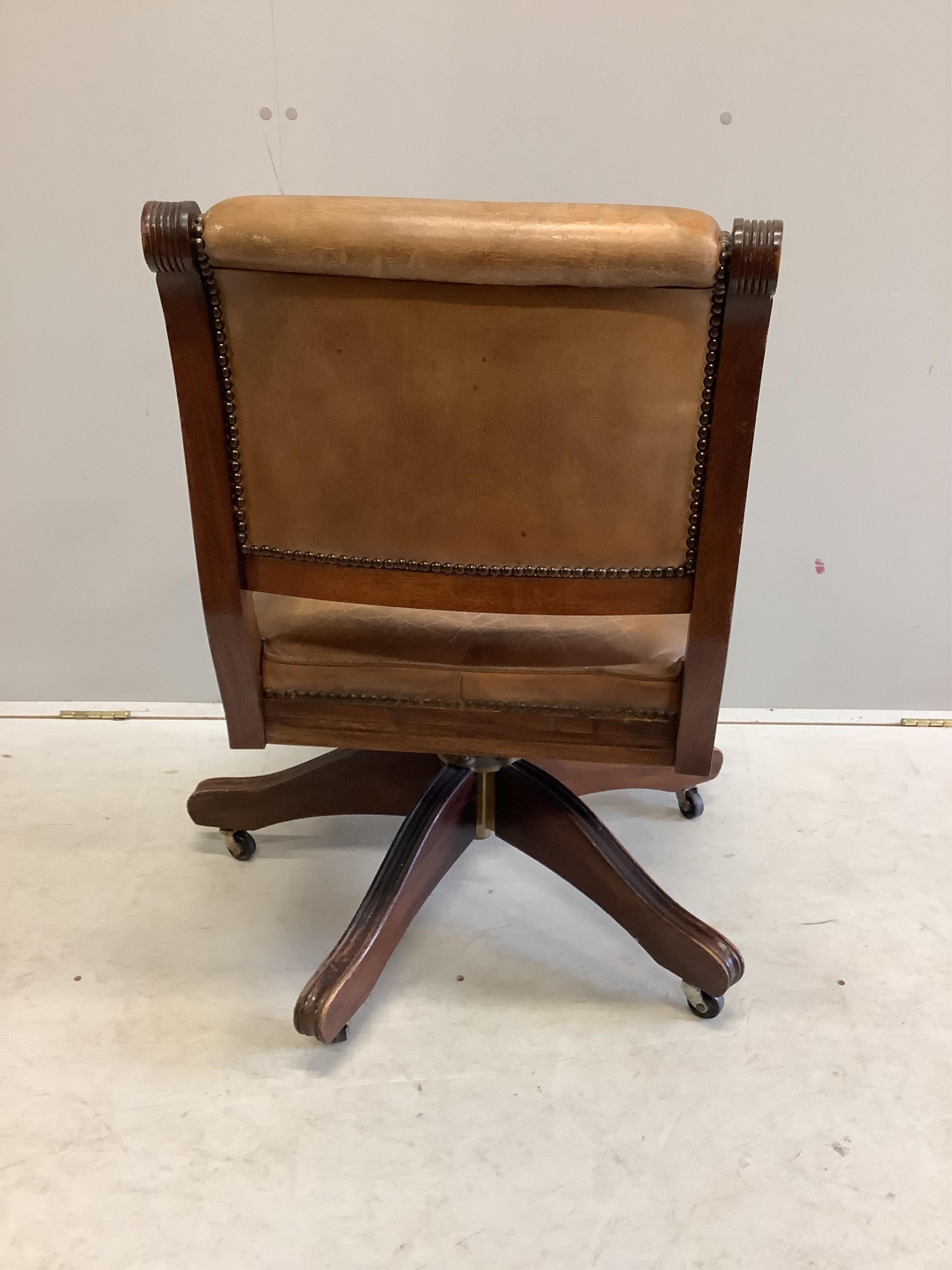 A reproduction mahogany and tan leather swivel desk chair, width 56cm, depth 52cm, height 84cm. Condition - fair